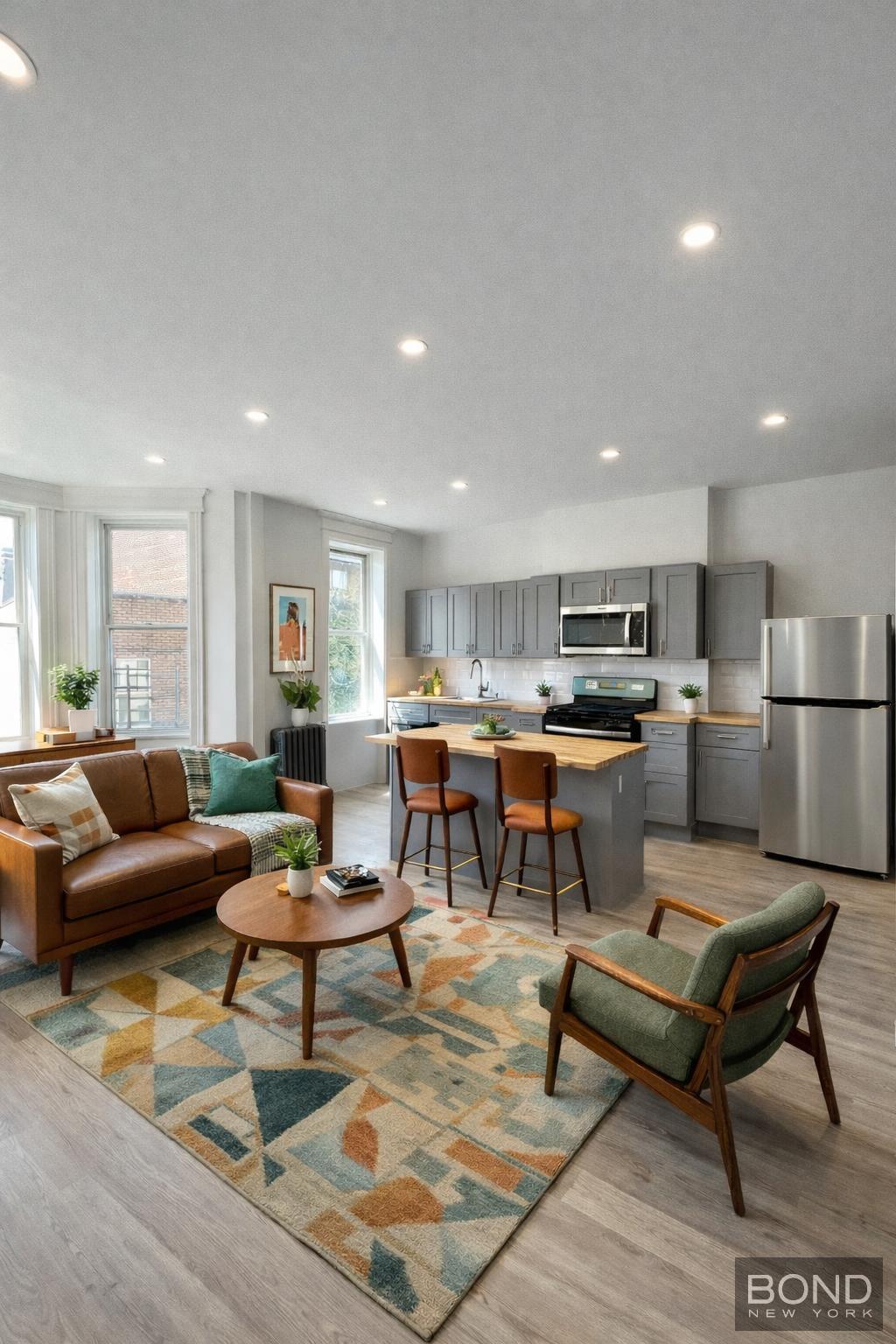 a living room with lots of furniture and kitchen view