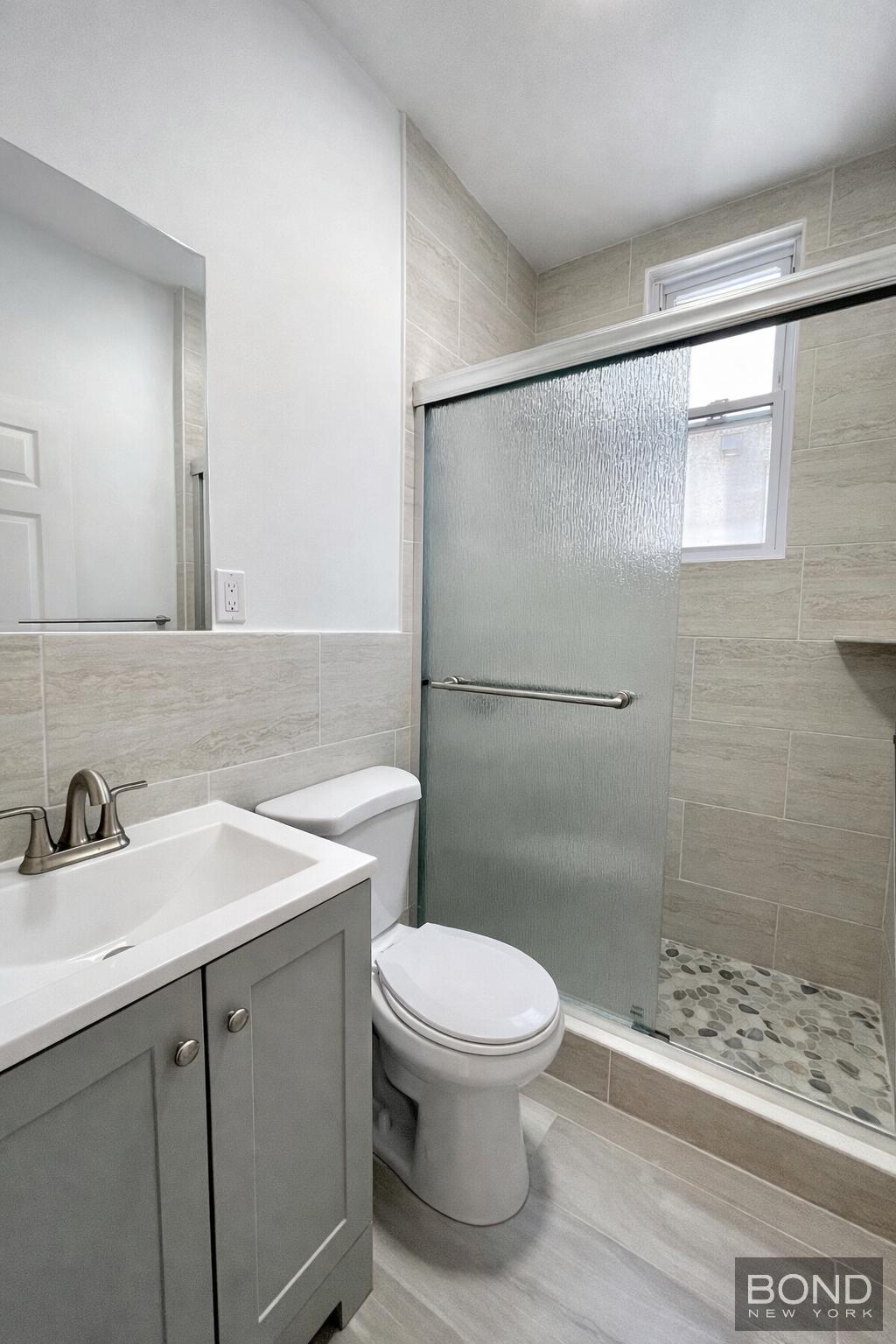 60-36 68th Road, Unit 2 Queens, NY 11385 - Photo 5 of 5 a bathroom with a sink a toilet and shower