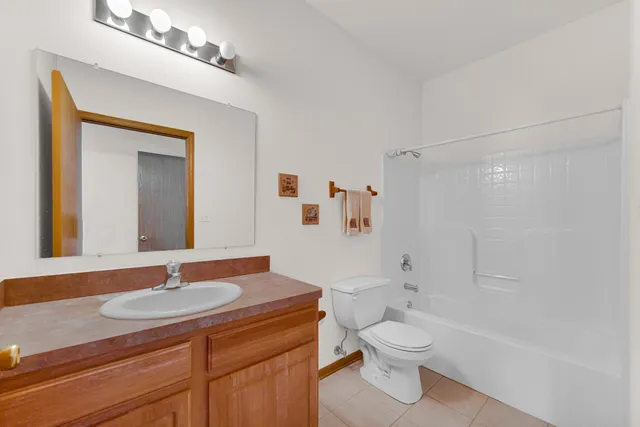 a bathroom with a granite countertop sink a toilet and a mirror