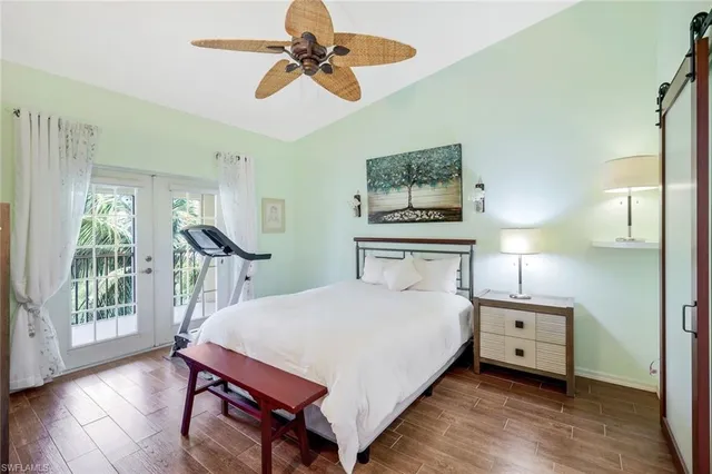 a bedroom with a bed a large window with table and chair