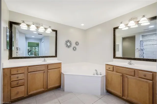 a bathroom with a sink vanity tub and a mirror