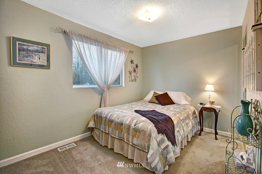611 204th Street Southeast Bothell, WA 98012 - Photo 11 of 24 a bedroom with a bed a lamp and a window