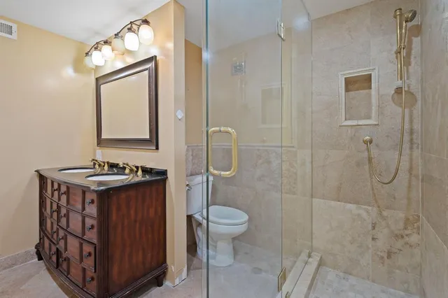 a bathroom with a granite countertop sink toilet and shower
