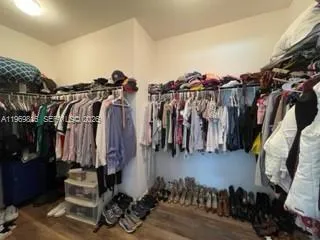 a view of walk in closet with clothes and shoes