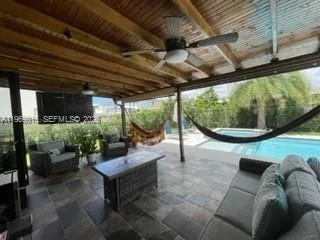 a living room with patio furniture and a potted plant