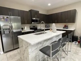 a kitchen with stainless steel appliances a sink a stove a refrigerator and cabinets