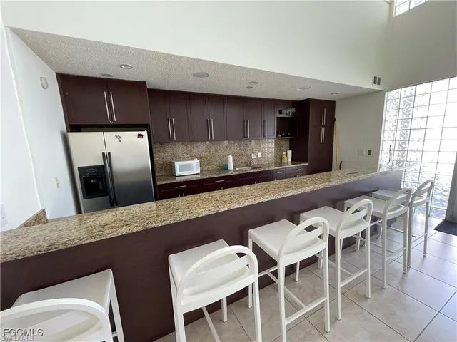 a kitchen with a table chairs sink and refrigerator