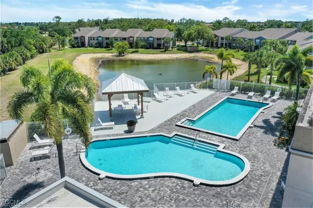an aerial view of a house with swimming pool and lake view