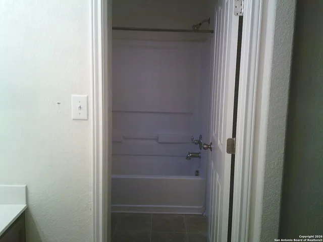 a view of an empty room with closet and mirror