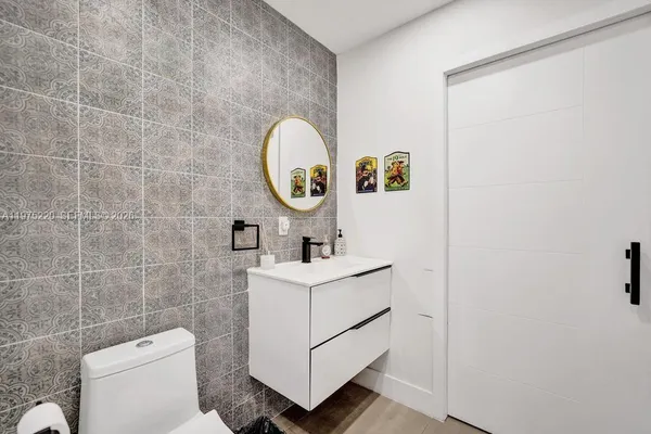 a bathroom with a sink a toilet a mirror and shower