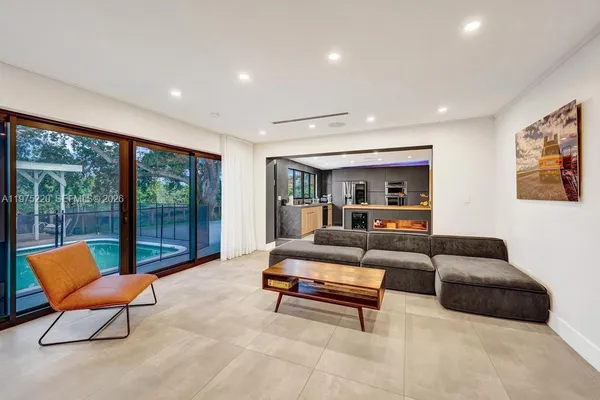 a living room with furniture and a floor to ceiling window
