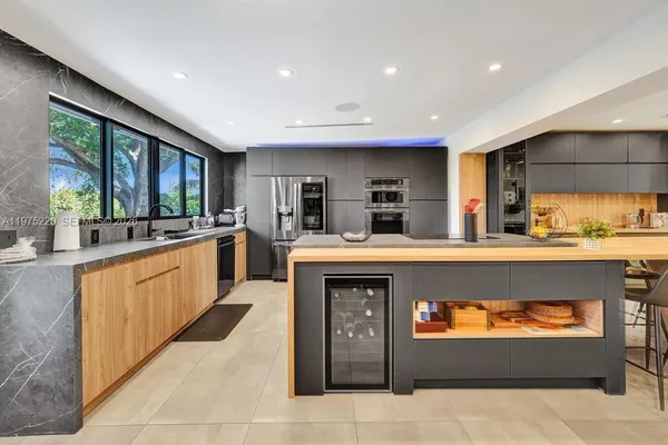 a large kitchen with stainless steel appliances granite countertop a large counter top and cabinets