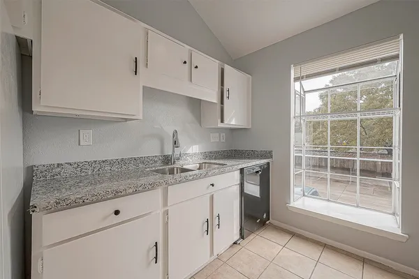 a kitchen with granite countertop white cabinets and a sink