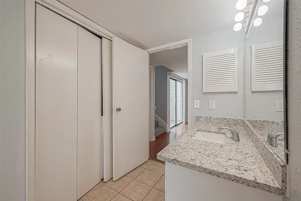 a bathroom with a granite countertop sink and a mirror
