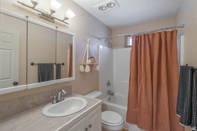 1504 Rome Way Apple Valley, UT 84737 - Photo 17 of 22 Bathroom featuring a single vanity with a laminate countertop, built-in medicine cabinet, white toilet, and tub/shower combination with white subway tile surround