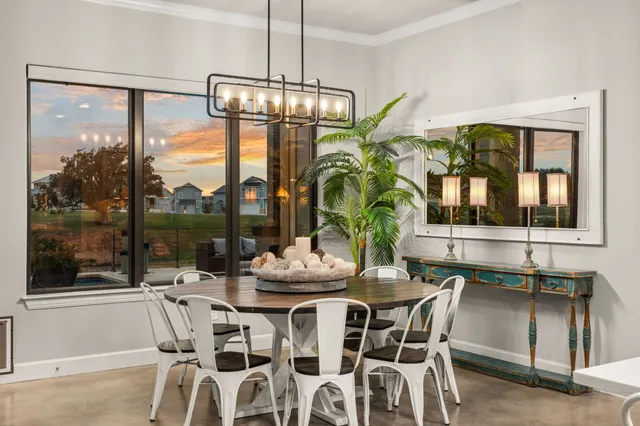 a dining room with furniture a chandelier and window