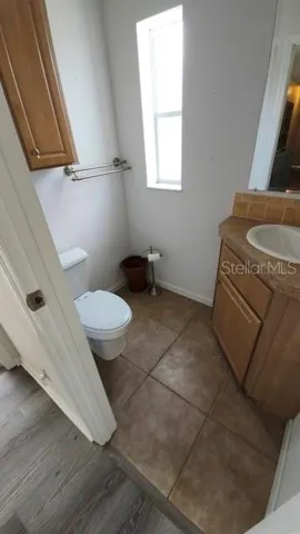 a bathroom with a granite countertop sink and a toilet