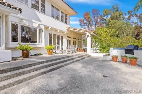 a view of a building with potted plants and a bench