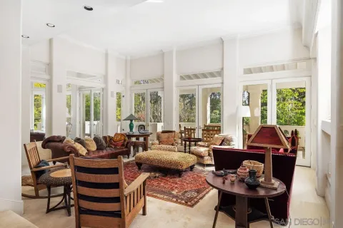 a living room with furniture and two large windows