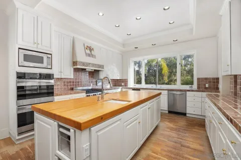 a large kitchen with stainless steel appliances granite countertop a large counter top and a stove
