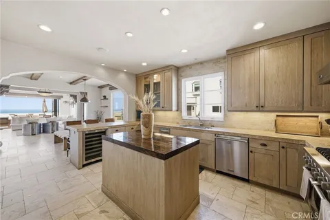 a kitchen with stainless steel appliances granite countertop a sink counter space and view of living room