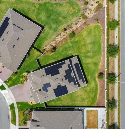 an aerial view of residential houses with outdoor space and ocean view