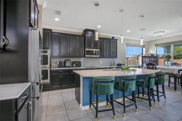 a kitchen with kitchen island granite countertop wooden cabinets and stainless steel appliances