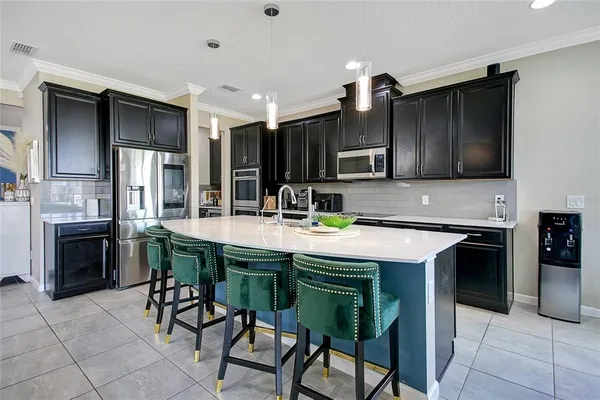 a kitchen with kitchen island granite countertop a sink a stove and refrigerator