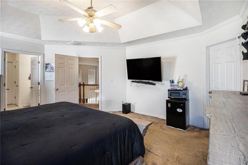 5610 Swanson Road Ellenwood, GA 30294 - Photo 14 of 28 a bedroom with a bed and a flat tv screen on the dresser