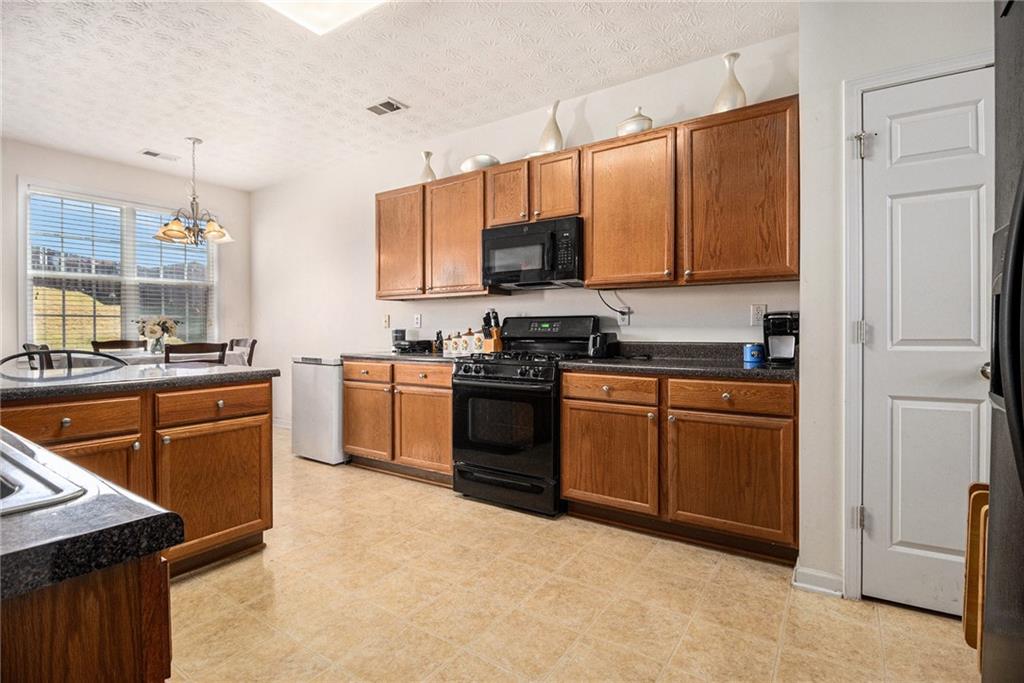5610 Swanson Road Ellenwood, GA 30294 - Photo 8 of 28 a kitchen with stainless steel appliances granite countertop a stove a sink and a refrigerator