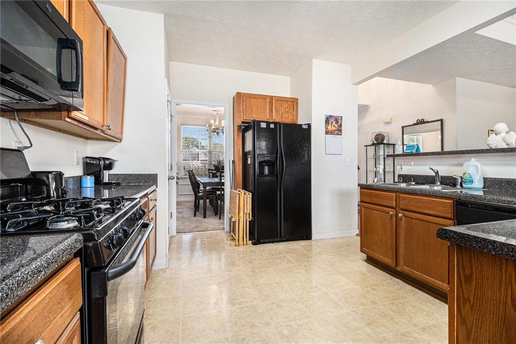 5610 Swanson Road Ellenwood, GA 30294 - Photo 9 of 28 a kitchen with stainless steel appliances granite countertop a sink stove and refrigerator