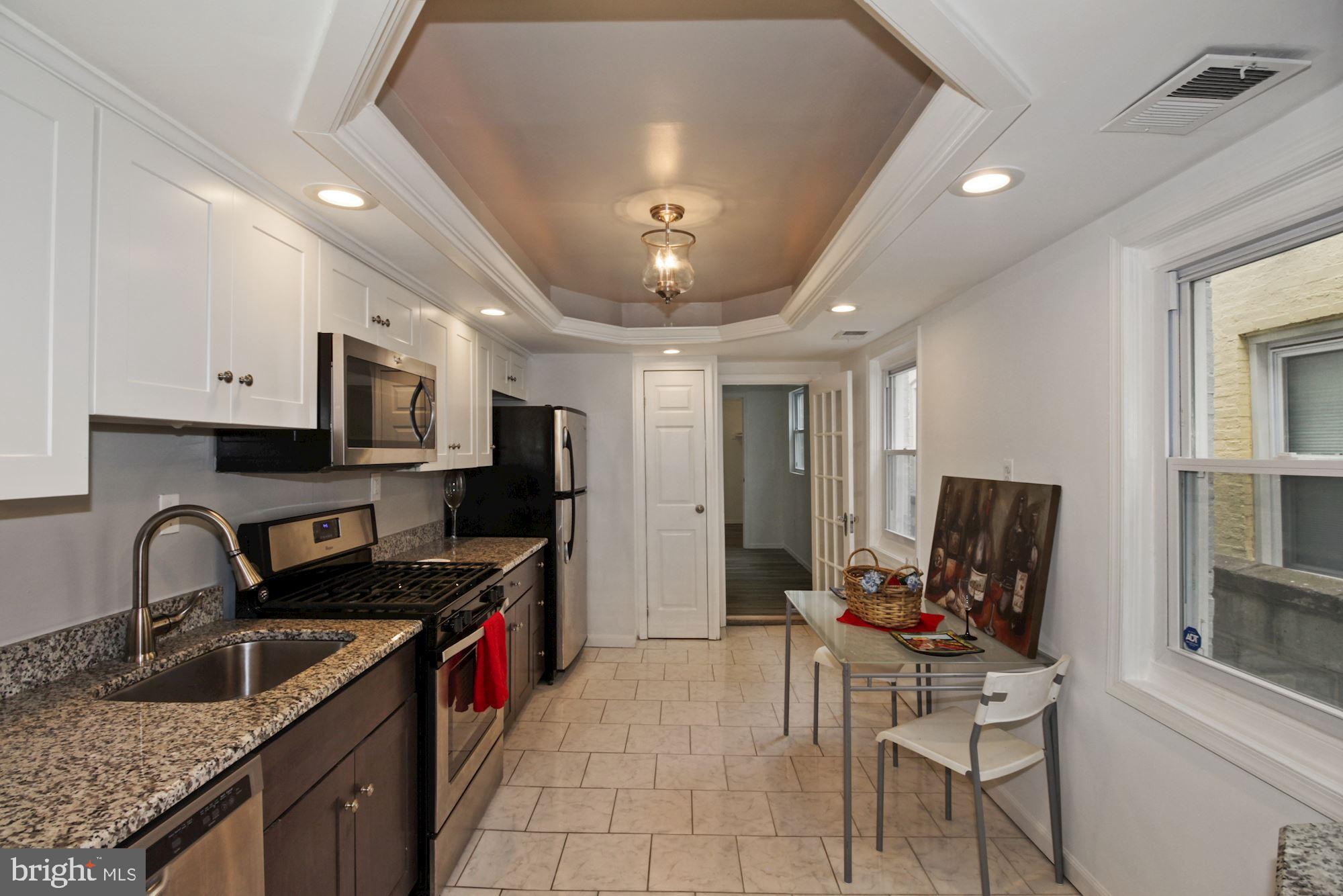 a kitchen with granite countertop a sink and appliances