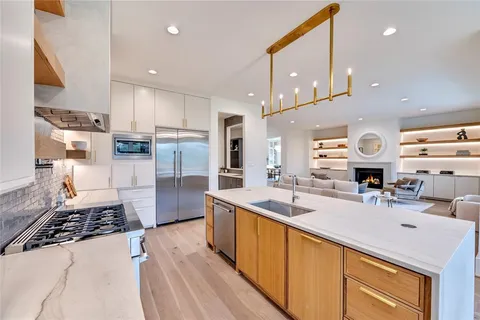 a kitchen with stainless steel appliances a sink a stove a refrigerator and cabinets