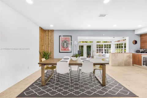 a dining room with wooden floor and large windows