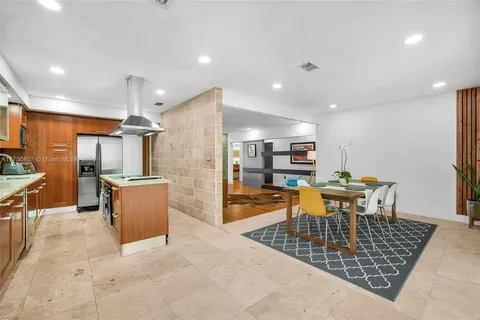 a large kitchen with lots of counter and chairs