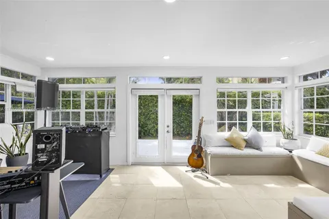 a living room with fireplace furniture and floor to ceiling windows