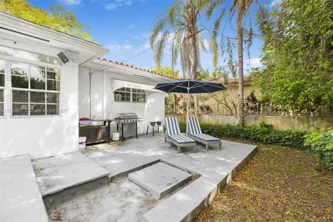 a view of a patio with a table and chairs under an umbrella