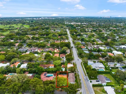 an aerial view of residential houses with outdoor space and trees