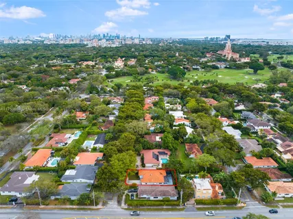 an aerial view of residential houses with outdoor space and trees