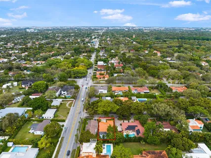 an aerial view of residential houses with outdoor space and trees