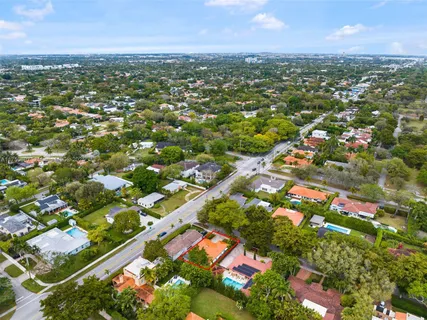 an aerial view of residential houses with outdoor space and trees