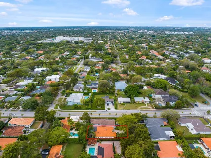 an aerial view of residential houses with outdoor space and trees