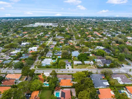 an aerial view of residential houses with outdoor space and trees
