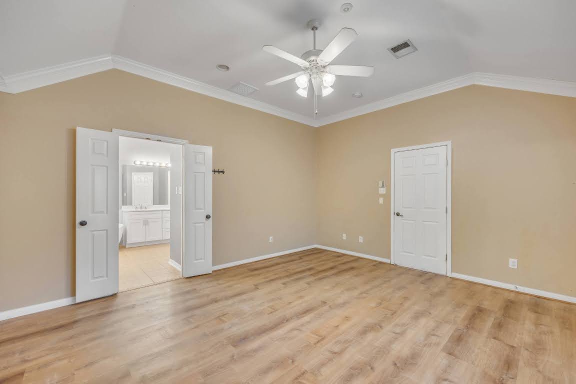 2726 Grimes Ranch Road Austin, TX 78732 - Photo 25 of 35 Empty room featuring lofted ceiling, crown molding, light wood-style flooring, and a ceiling fan