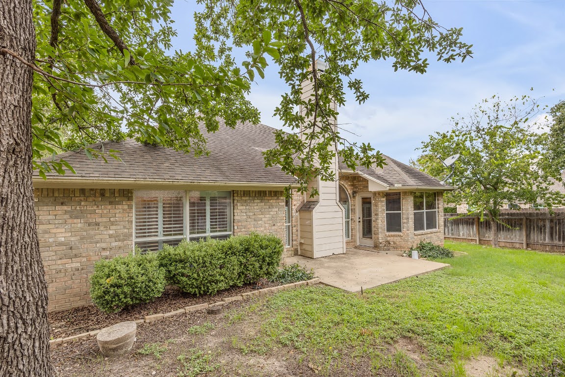 2726 Grimes Ranch Road Austin, TX 78732 - Photo 35 of 35 Rear view of house with a patio, a shingled roof, and brick siding