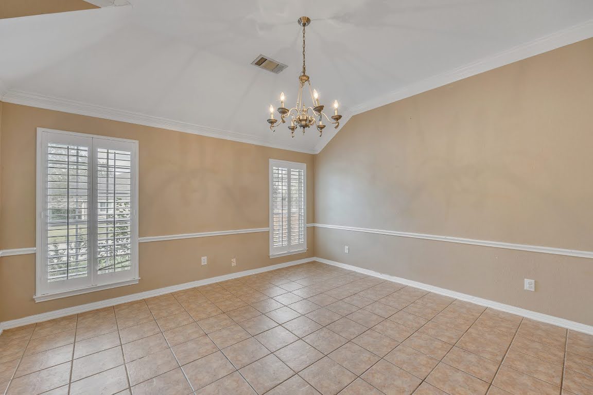 2726 Grimes Ranch Road Austin, TX 78732 - Photo 5 of 35 Empty room featuring lofted ceiling, a chandelier, ornamental molding, and light tile patterned flooring