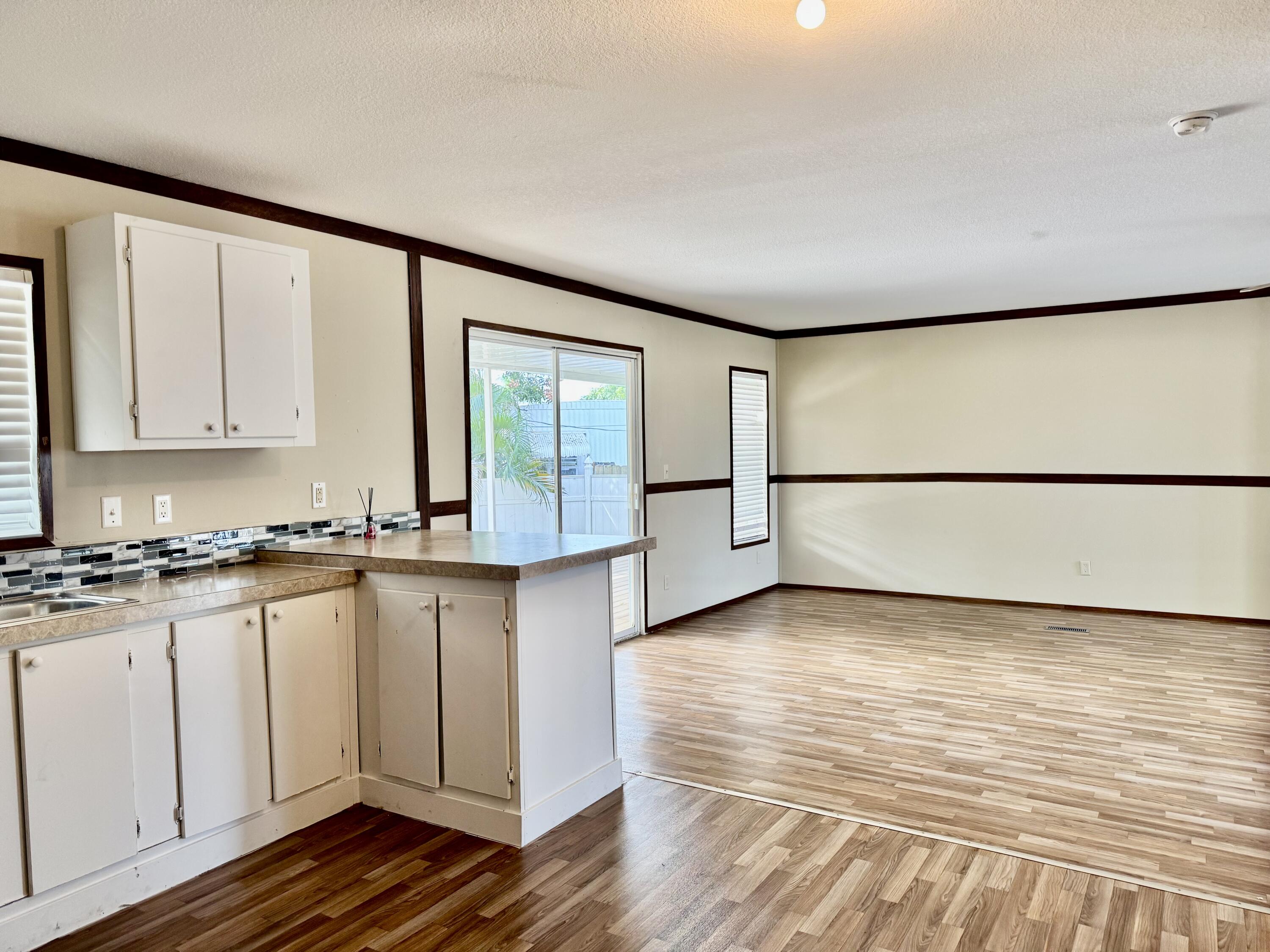 3200 Southeast 18th Court Okeechobee, FL 34974 - Photo 14 of 21 a kitchen with granite countertop white cabinets and a dishwasher next to a large window