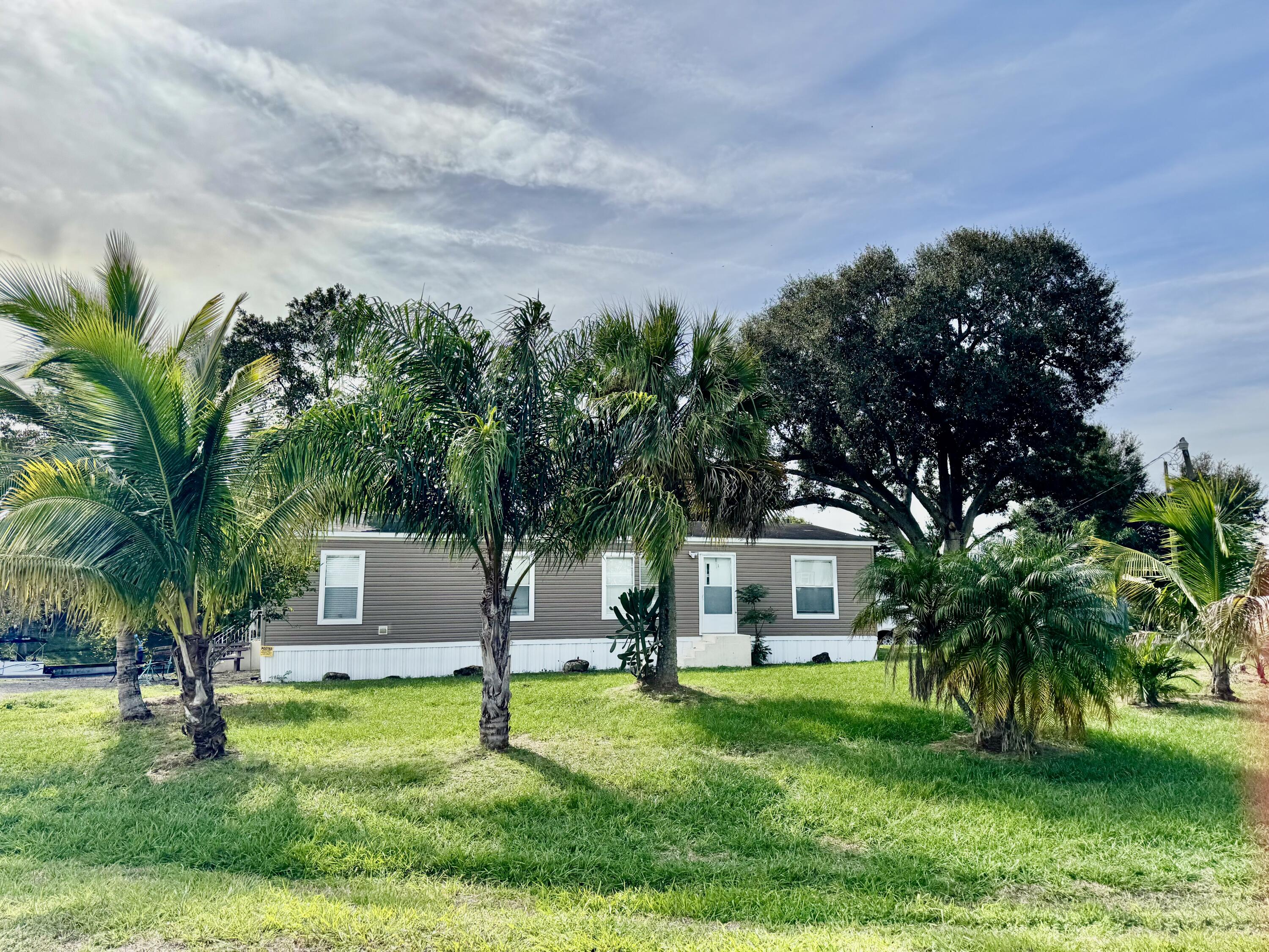 3200 Southeast 18th Court Okeechobee, FL 34974 - Photo 20 of 21 a house with palm tree in front of it