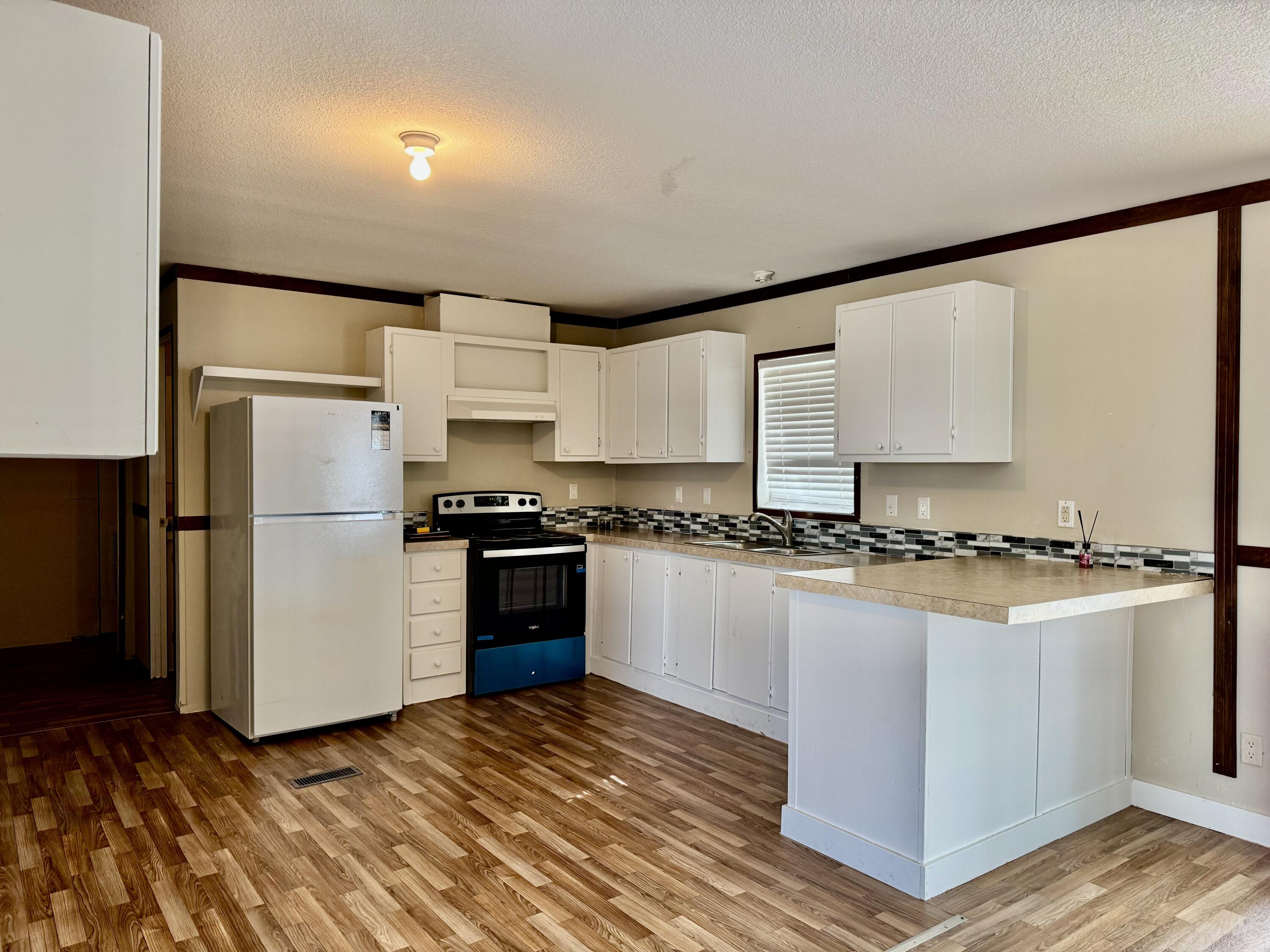 3200 Southeast 18th Court Okeechobee, FL 34974 - Photo 4 of 21 a kitchen with stainless steel appliances granite countertop a refrigerator and a stove