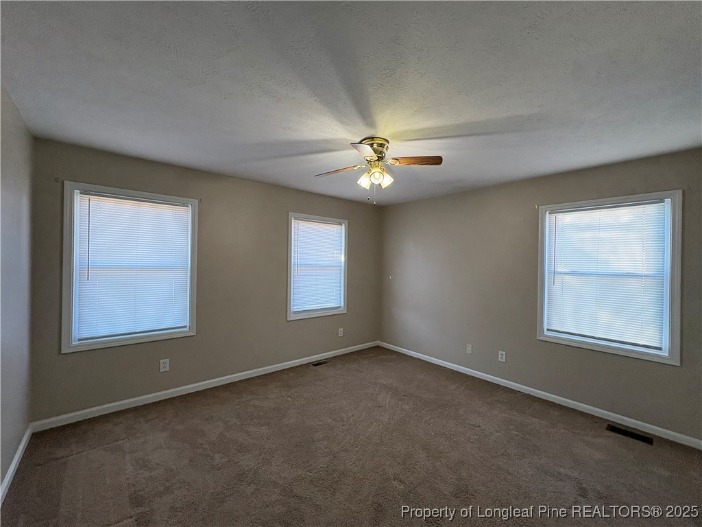 4639 Legion Road Hope Mills, NC 28348 - Photo 22 of 35 an empty room with windows and chandelier fan